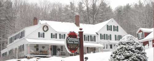 A snowy scene of a charming inn with green shutters, a festive wreath, and a sign reading "Christmas Farm Inn."