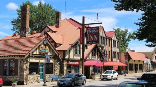 A charming street view featuring the English Inn and nearby shops, with blue skies and trees in the background.