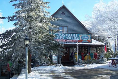 A charming general store with a colorful sign, surrounded by snow-covered trees and a clear blue sky.