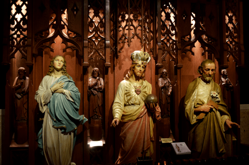 Statues of Mary, Jesus, and Joseph in a beautifully carved wooden altar setting.