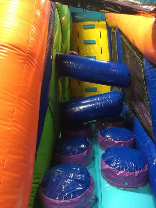 Colorful inflatable obstacle course with blue and purple tubes and circular platforms.