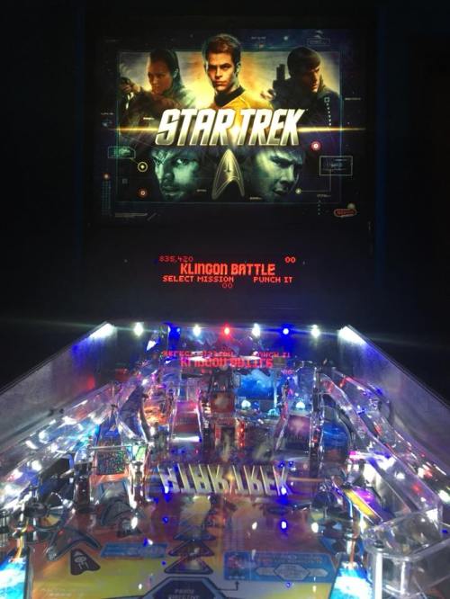 A pinball machine featuring a "Star Trek" theme, with vibrant lights and a display showing characters from the franchise.