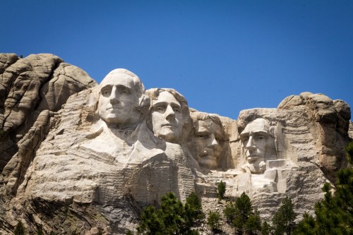Mount Rushmore featuring the carved faces of four U.S. presidents against a clear blue sky.