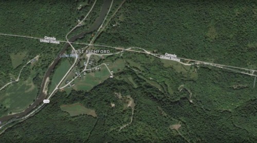 Aerial view of East Richford, Vermont, near the Canada-U.S. border, surrounded by dense greenery and a river.
