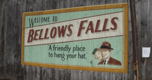 Sign welcoming visitors to Bellows Falls, featuring the phrase "A friendly place to hang your hat."