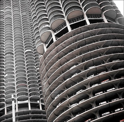 A close-up of a modern high-rise building with curved balconies and a unique architectural design.