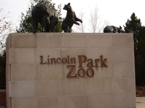 Sign for Lincoln Park Zoo featuring sculptures of bears on top of a stone wall.