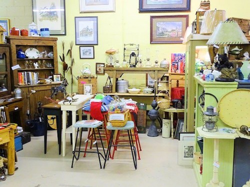 A cozy antique shop filled with various vintage items, furniture, and decor arranged on shelves and tables.