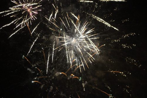 Colorful fireworks burst in the night sky, creating a dazzling display of light and sparks.