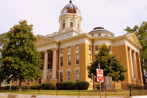 Historic building with a clock tower, surrounded by trees and a "Do Not Enter" sign in the foreground.