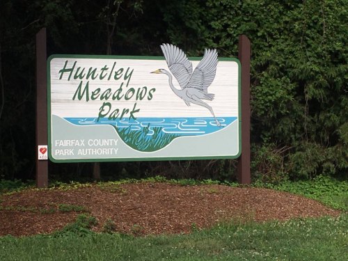 Sign for Huntley Meadows Park featuring a heron and greenery, indicating it's part of Fairfax County Park Authority.