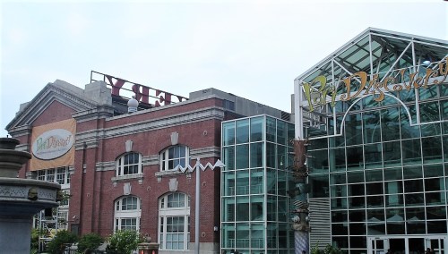 A view of two buildings: one with a vintage brick facade and the other with a modern glass design.