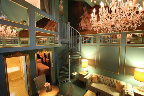 Elegant room with a spiral staircase, plush seating, chandeliers, and ornate mirrors reflecting a luxurious atmosphere.