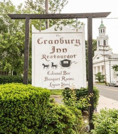 Sign for Cragbury Ivy Restaurant featuring Colonial Bar, banquet rooms, and a liquor store, surrounded by greenery.