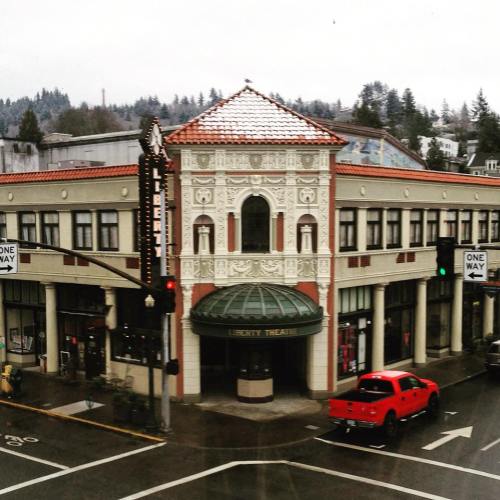 Historic Liberty Theatre building with ornate architecture, surrounded by trees and a red truck parked nearby.
