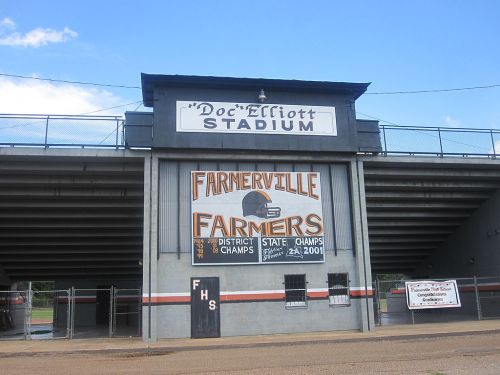 Front view of Doc Elliott Stadium, featuring a sign for the Farmerville Farmers and their championship titles.