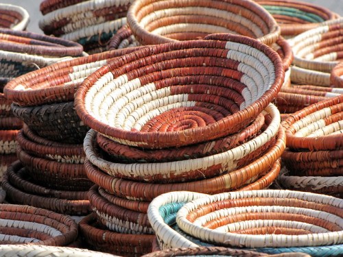 A colorful stack of woven baskets in various sizes and patterns, showcasing intricate craftsmanship.