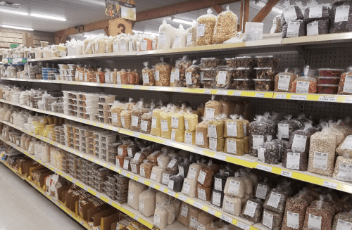 A grocery store aisle filled with various packaged grains, nuts, and snacks on shelves.