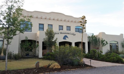 Exterior view of Bear Mountain Lodge, featuring a southwestern architectural style and surrounding greenery.