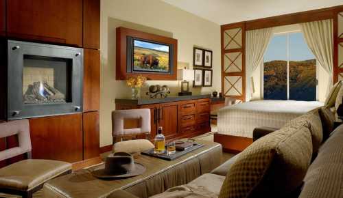 Cozy hotel room featuring a fireplace, large window with a view, and stylish furnishings.