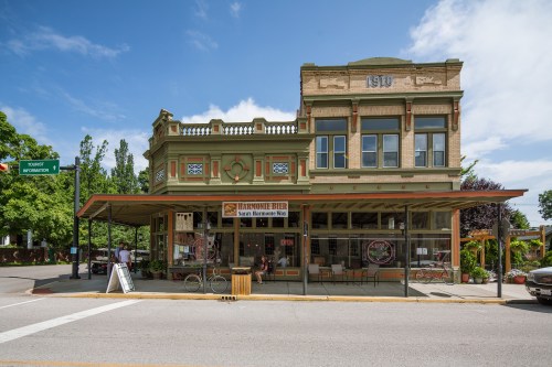 Historic building with ornate architecture, featuring a café and outdoor seating under a canopy on a sunny day.