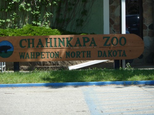 Sign for Chahinkapa Zoo in Wahpeton, North Dakota, featuring a wooden design and green surroundings.