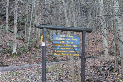 Sign for Zoar Valley Multiple Use Area in New York, detailing its size and conservation status, surrounded by trees.