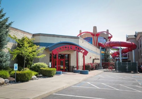 Entrance to a family entertainment center featuring colorful water slides and lush landscaping.