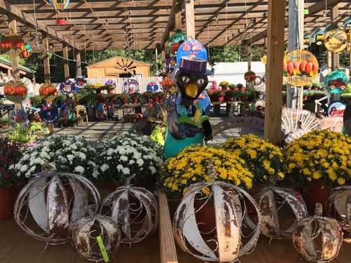 A colorful display of flowers and pumpkins with a whimsical statue in a festive market setting.