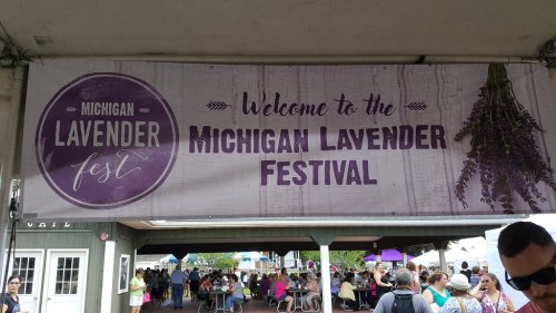 Banner welcoming visitors to the Michigan Lavender Festival, featuring lavender graphics and a crowd in the background.