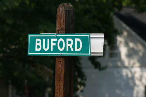 A green street sign on a wooden post displaying the name "BUFORD."