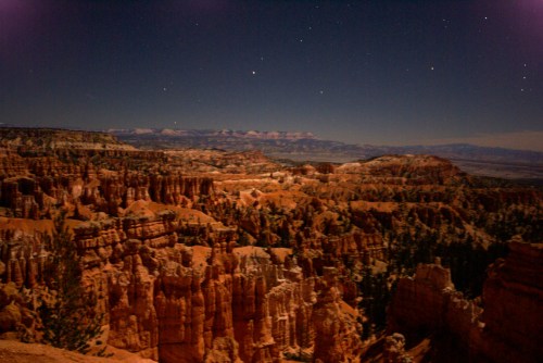 A moonlit landscape of Bryce Canyon, showcasing its unique rock formations and starry sky.