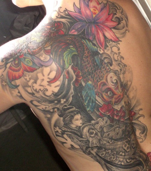 A colorful tattoo featuring a koi fish, flowers, and a figure in traditional attire on a person's shoulder and back.