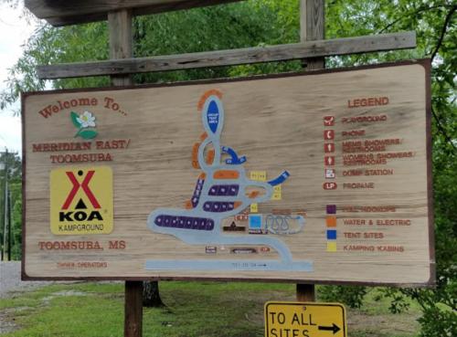 Sign for Meridian East KOA Campground in Toomsuba, MS, featuring a map and legend of facilities and camping sites.