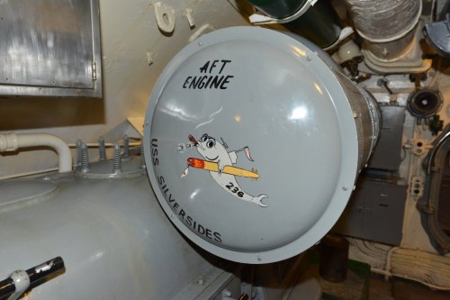 A round gray panel labeled "AFT ENGINE" with a cartoon mouse holding a torpedo, on the USS Silversides submarine.