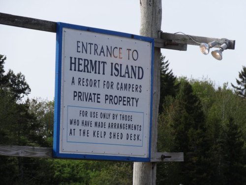 Sign for Hermit Island, indicating it's a private resort for campers, with instructions to check in at the Kelp Shed desk.