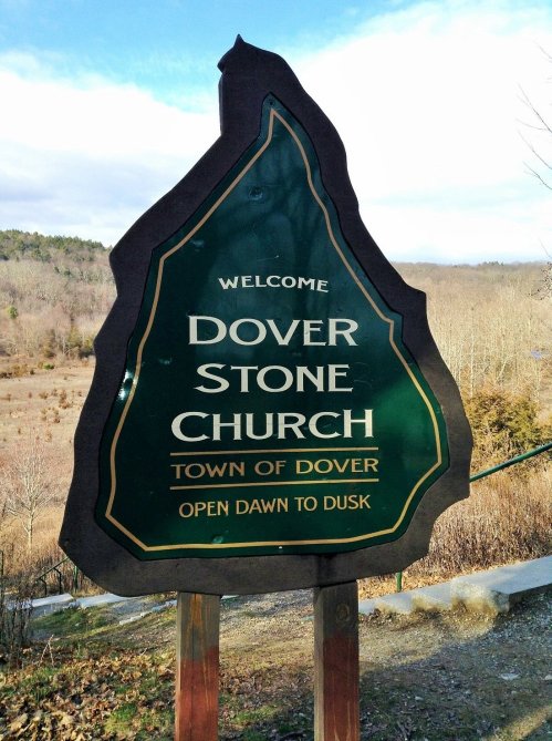 Welcome sign for Dover Stone Church, Town of Dover, stating "Open Dawn to Dusk" against a natural backdrop.