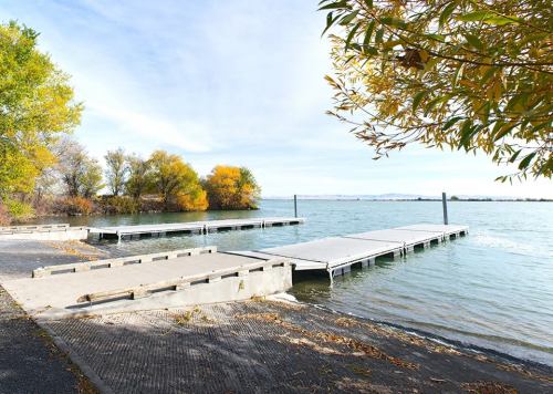 A serene lakeside view featuring wooden docks and colorful autumn trees along the water's edge.