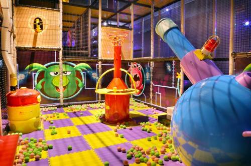 Colorful indoor play area with ball pits, climbing structures, and playful wall designs. Perfect for kids' fun and exploration.