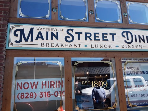 Sign for Main Street Diner in Waynesville, featuring "Breakfast, Lunch, Dinner" and a "Now Hiring" notice.
