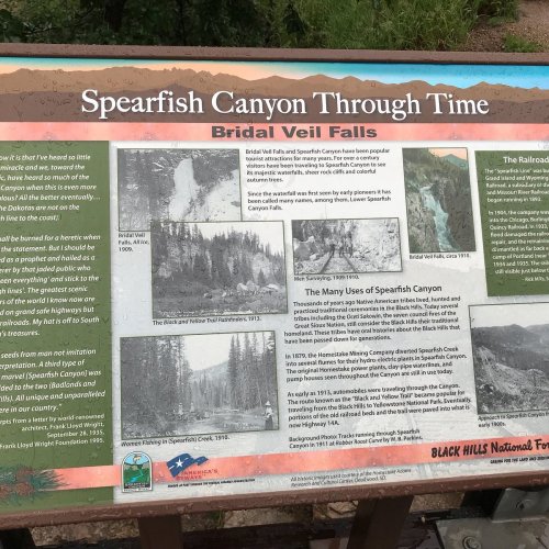 Informational sign about Spearfish Canyon's history, featuring images of Bridal Veil Falls and details on its uses over time.