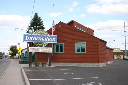 A brown wooden building with a sign reading "Information Center" and an American flag, set against a cloudy sky.