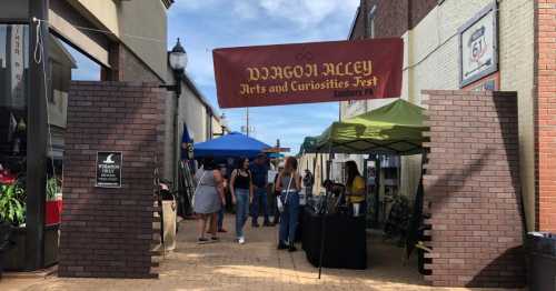 Entrance to Dragon Alley Arts and Curiosities Fest in Sunbury, PA, with vendors and colorful tents.