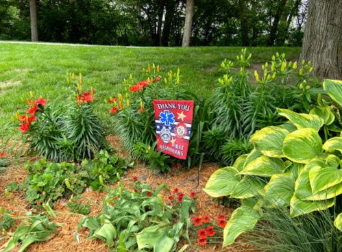 A garden with colorful flowers and a sign that reads "Thank You First Responders."