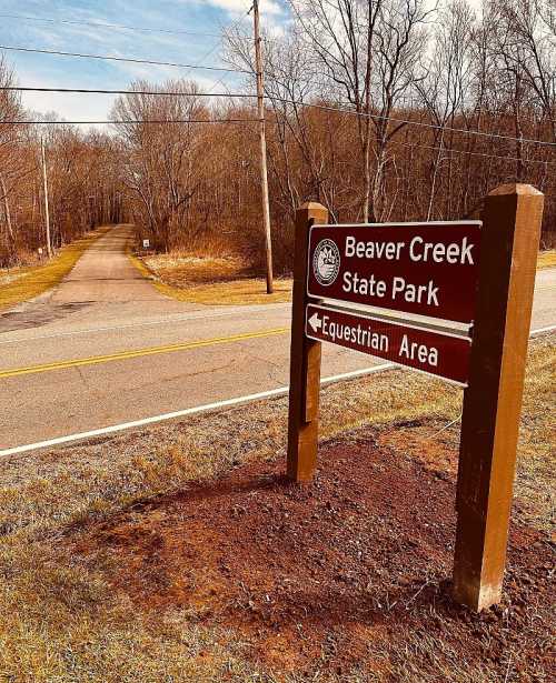 Sign for Beaver Creek State Park with directions to the equestrian area, set against a wooded background.