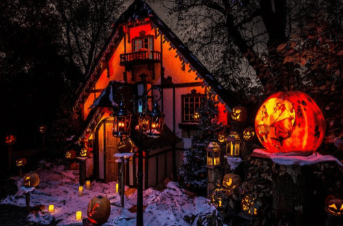A spooky house decorated with glowing jack-o'-lanterns and lanterns, set against a dark, eerie night sky.