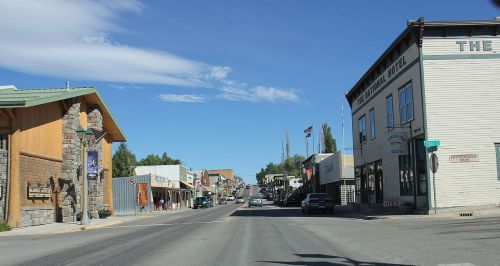 A quiet street scene featuring historic buildings and shops under a clear blue sky.