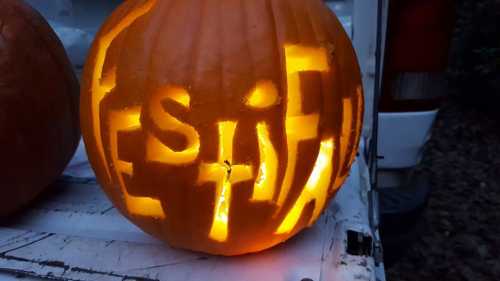 A carved pumpkin with the word "FESTIVAL" illuminated from within, sitting on a white surface.