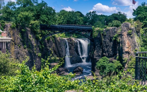 Waterfall view under an old steel bridge