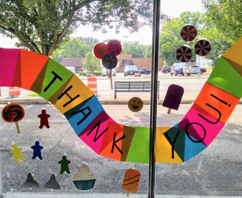 Colorful window decorations with the text "THANK YOU!" and various candy and dessert shapes.